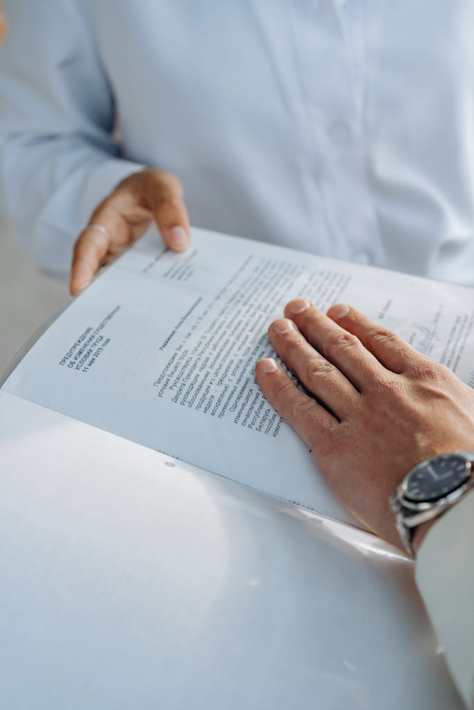 Close-up of hands reviewing a business agreement document. Professional setting.